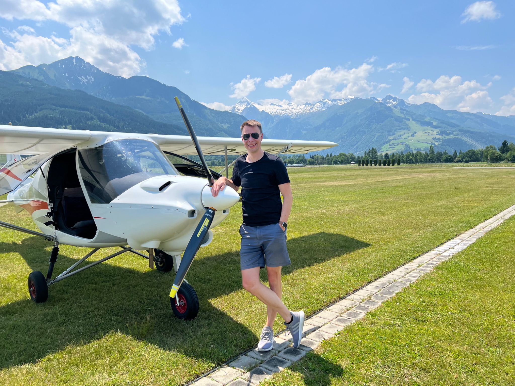 Stefan Billerbeck neben einem Flugzeug vor einer Bergkulisse